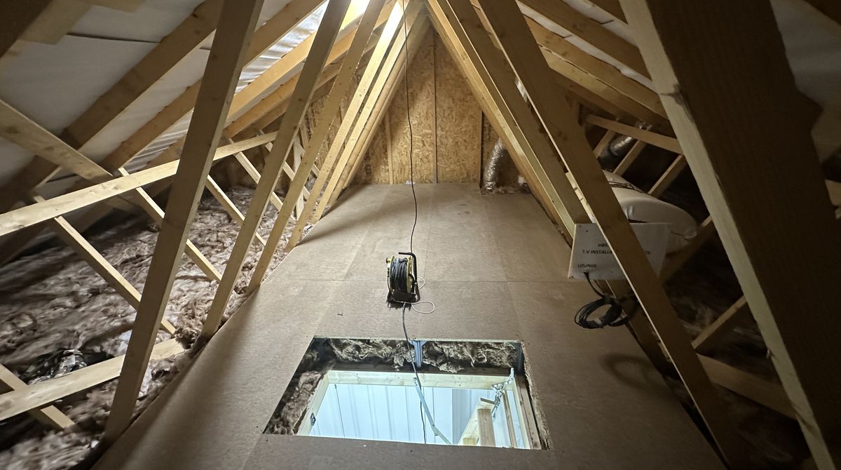 Chipboard loft boarding laid down the centre of a trussed-roof loft around the hatch opening, fitted by our team